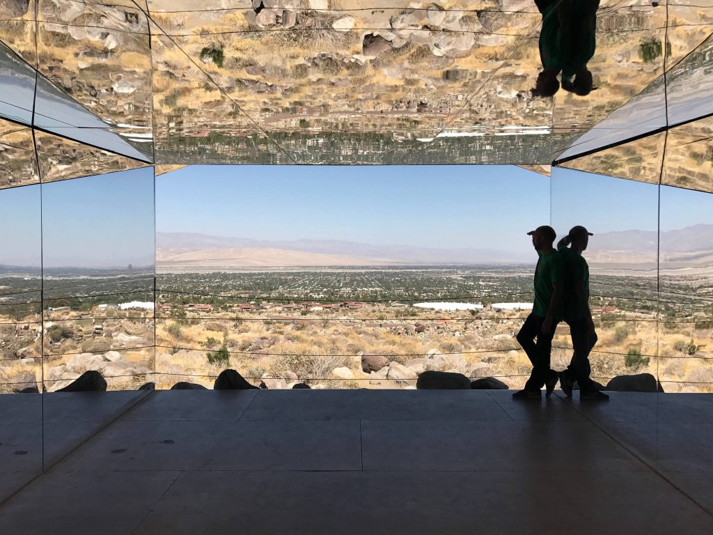 Ansgar Halbfas standing inside a building made from mirrors giving a guided architectural tour for a celebrity in Palm Springs California USA.
